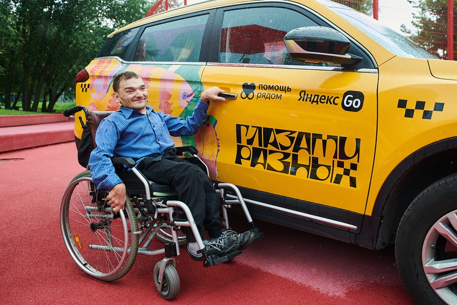 Кирилл Шмырков на фоне такси с нанесённым принтом его картины.jpg